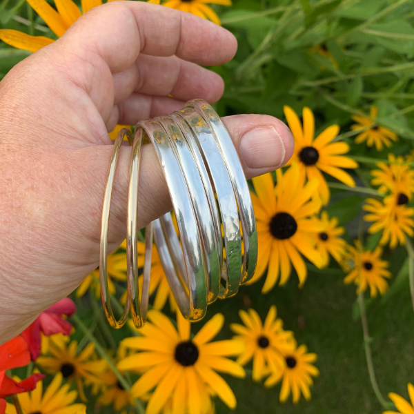 handful of sterling silver bangles. Handmade in the Uk by Laura De Zordo Jewellery